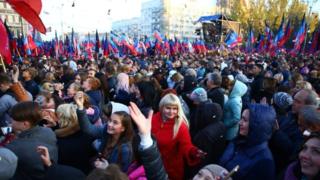 Crowds of people wave flags and Hold up Telephones in the Donesk Republicss as  await  Off-book leader,  Pushilin